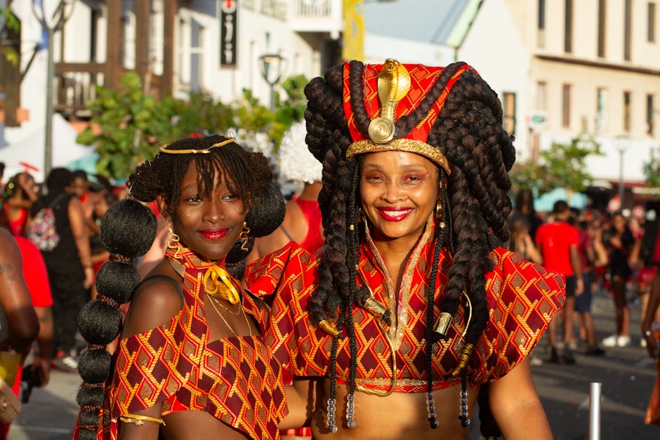 Two women in ornate costumes joyfully celebrating at an outdoor carnival event
